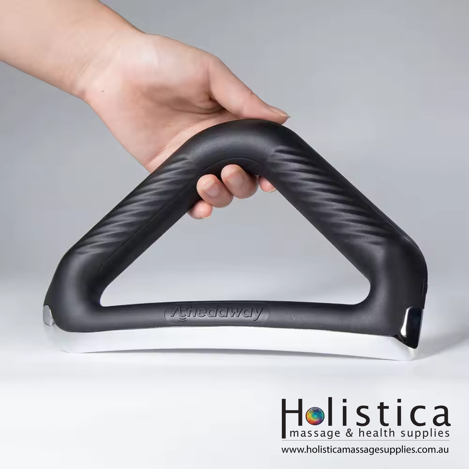 A hand holding a heated electrical scraper, used by a massage therapist for muscle therapy.